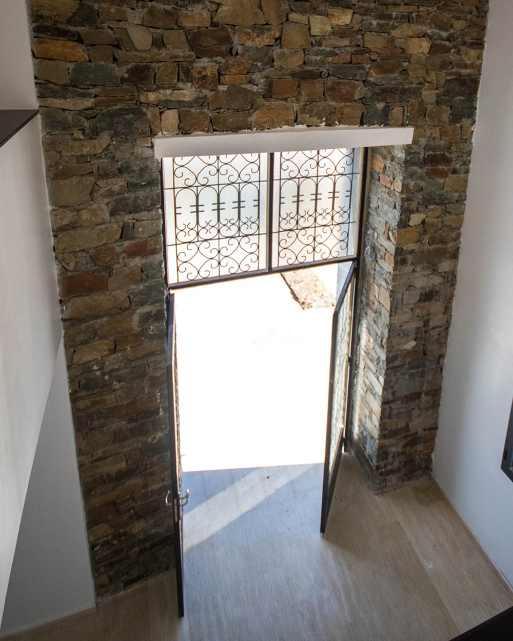 Mur intérieur en pierre éclairé par la porte d'entrée