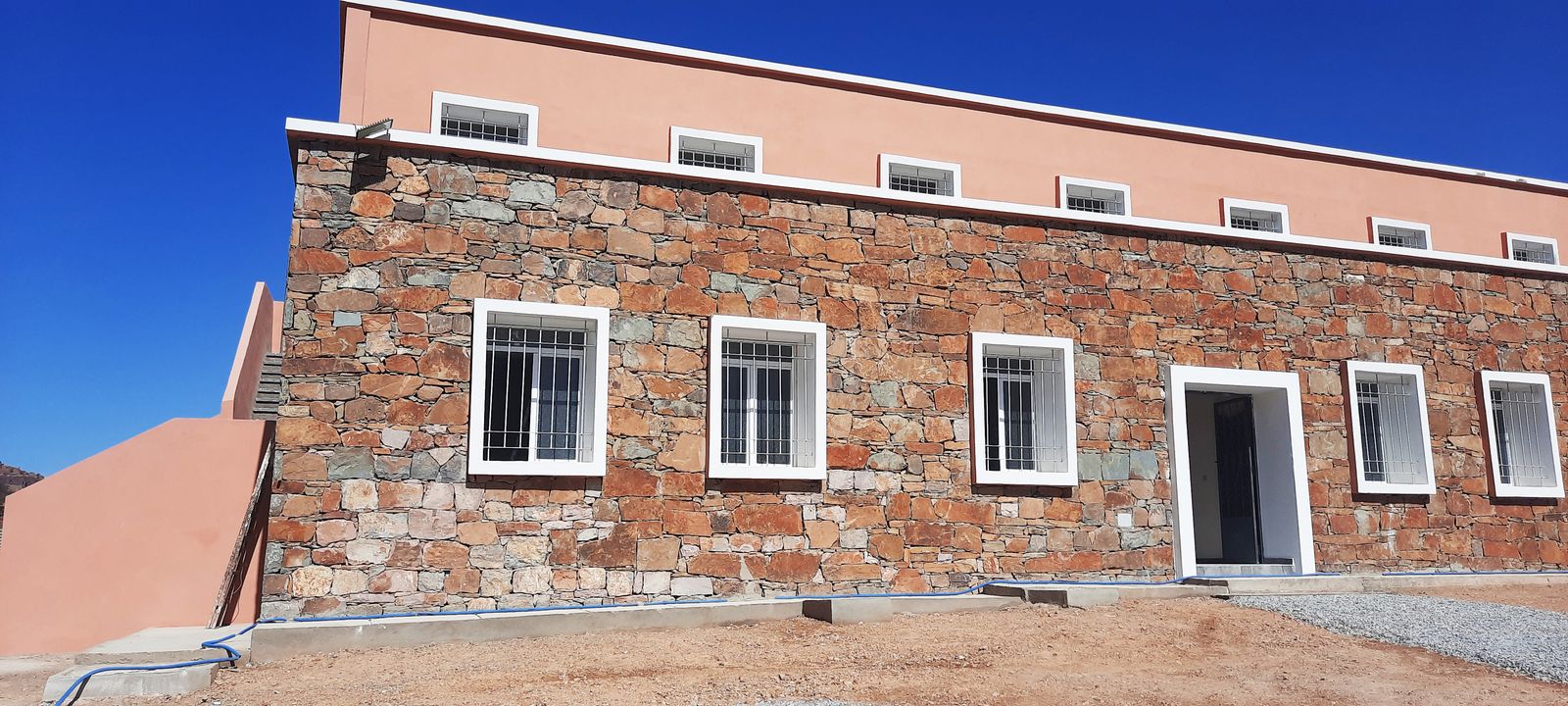 Façade en pierre de l'internat, fenêtres à encadrement blanc